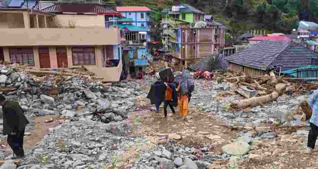 Locals carry their belongings as they walk amid the debris at a flood-affected area, at Thunag in Mandi district, Monday, July 7, 2025. Since the onset of monsoon, Himachal Pradesh has reported 78 deaths, of which 50 were linked to rain-related incidents such as cloudbursts, flash floods and landslides. (PTI Photo) Locals carry their belongings as they walk amid the debris at a flood-affected area, at Thunag in Mandi district, Monday, July 7, 2025. Since the onset of monsoon, Himachal Pradesh has reported 78 deaths, of which 50 were linked to rain-related incidents such as cloudbursts, flash floods and landslides. (PTI Photo)