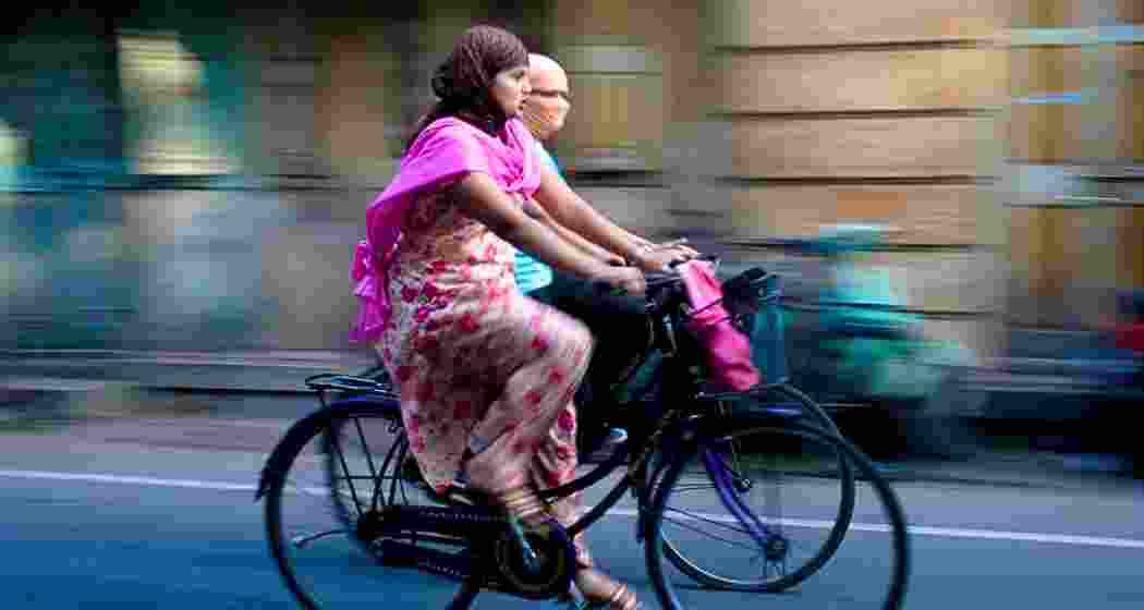 Two women ride bicycles in Jaipur, Rajasthan. Two women ride bicycles in Jaipur, Rajasthan.