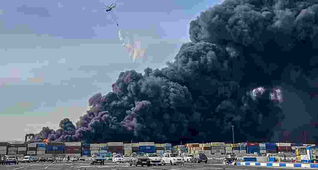 A helicopter douses the massive fire at Shahid Rajaei port in Iran after an explosion linked to missile fuel chemicals killed 18 people and injured hundreds on Saturday (local time). A helicopter douses the massive fire at Shahid Rajaei port in Iran after an explosion linked to missile fuel chemicals killed 18 people and injured hundreds on Saturday (local time).