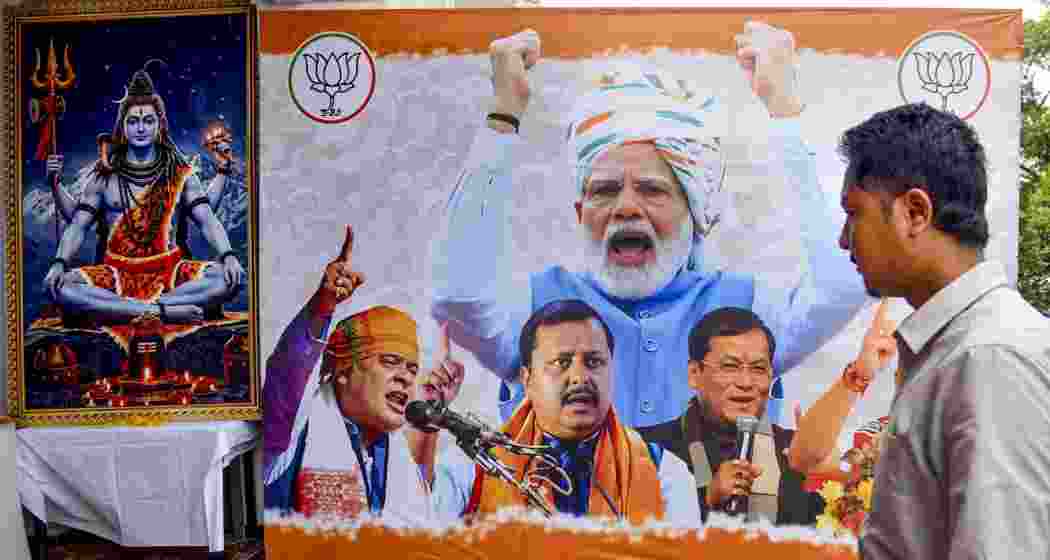 A man passes by a huge hoarding of BJP during the Assam Assembly elections result day, in Guwahati, on Monday. A man passes by a huge hoarding of BJP during the Assam Assembly elections result day, in Guwahati, on Monday.