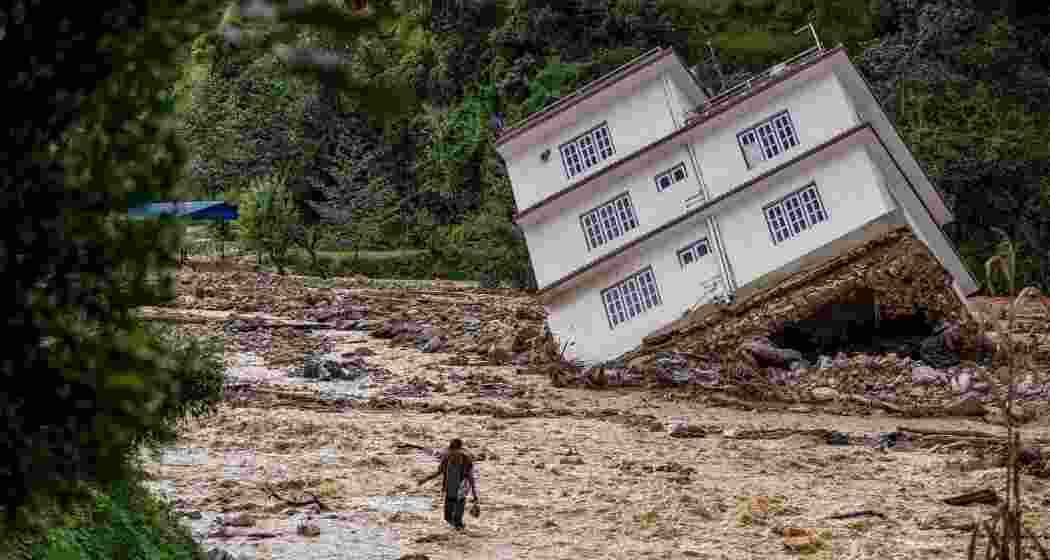 A man wades through the waters in the affected area of monsoon flooding in Roshi village of Kavre district, Nepal on September 30, 2024. A man wades through the waters in the affected area of monsoon flooding in Roshi village of Kavre district, Nepal on September 30, 2024.