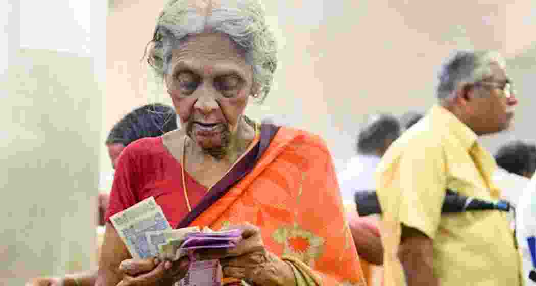 An old-aged lady carefully counts her pension money. An old-aged lady carefully counts her pension money.
