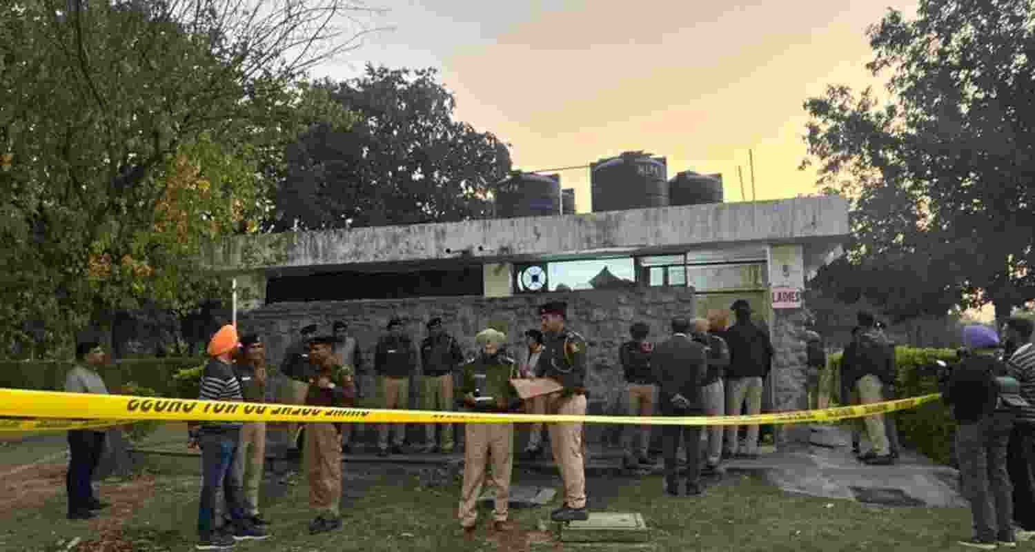 Police officials examining the scene of crime after cordoning off the area. Police officials examining the scene of crime after cordoning off the area.