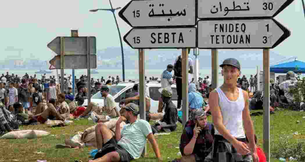 Migrants rest after crossing back from the Spanish enclave of Ceuta, to the Moroccan side of the border in Fnideq, Morocco. Migrants rest after crossing back from the Spanish enclave of Ceuta, to the Moroccan side of the border in Fnideq, Morocco.