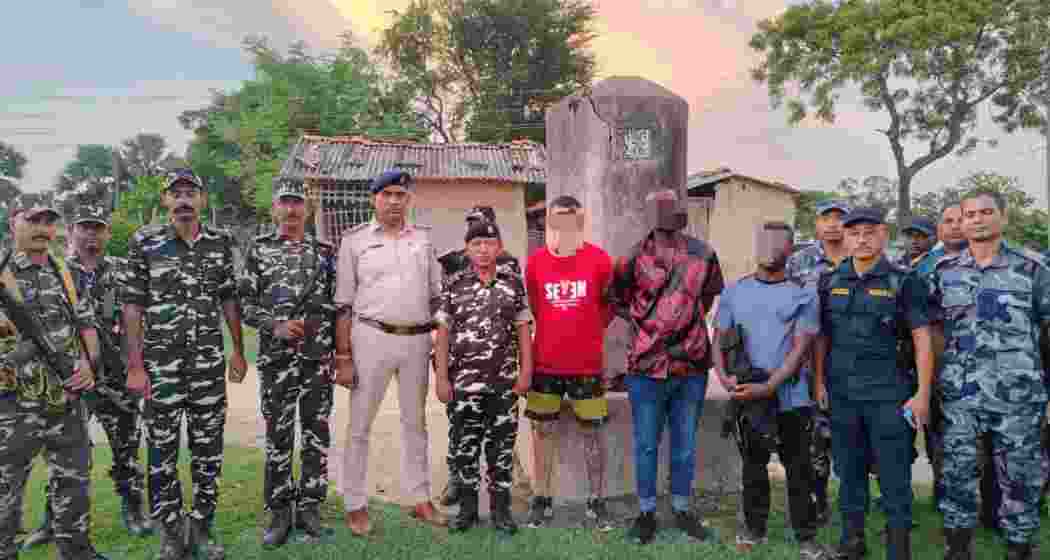 SSB personnel stand with the detained Brazilian and Nigerian nationals. SSB personnel stand with the detained Brazilian and Nigerian nationals.