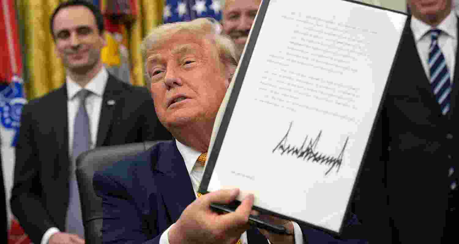 US President Donald Trump holds up a signed executive order at the White House. US President Donald Trump holds up a signed executive order at the White House.