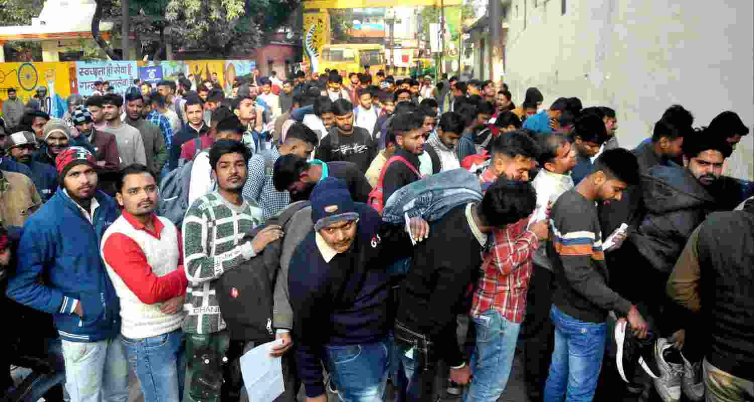 Candidates wait outside an examination centre to appear in the UP Police Constable recruitment exam. Candidates wait outside an examination centre to appear in the UP Police Constable recruitment exam.