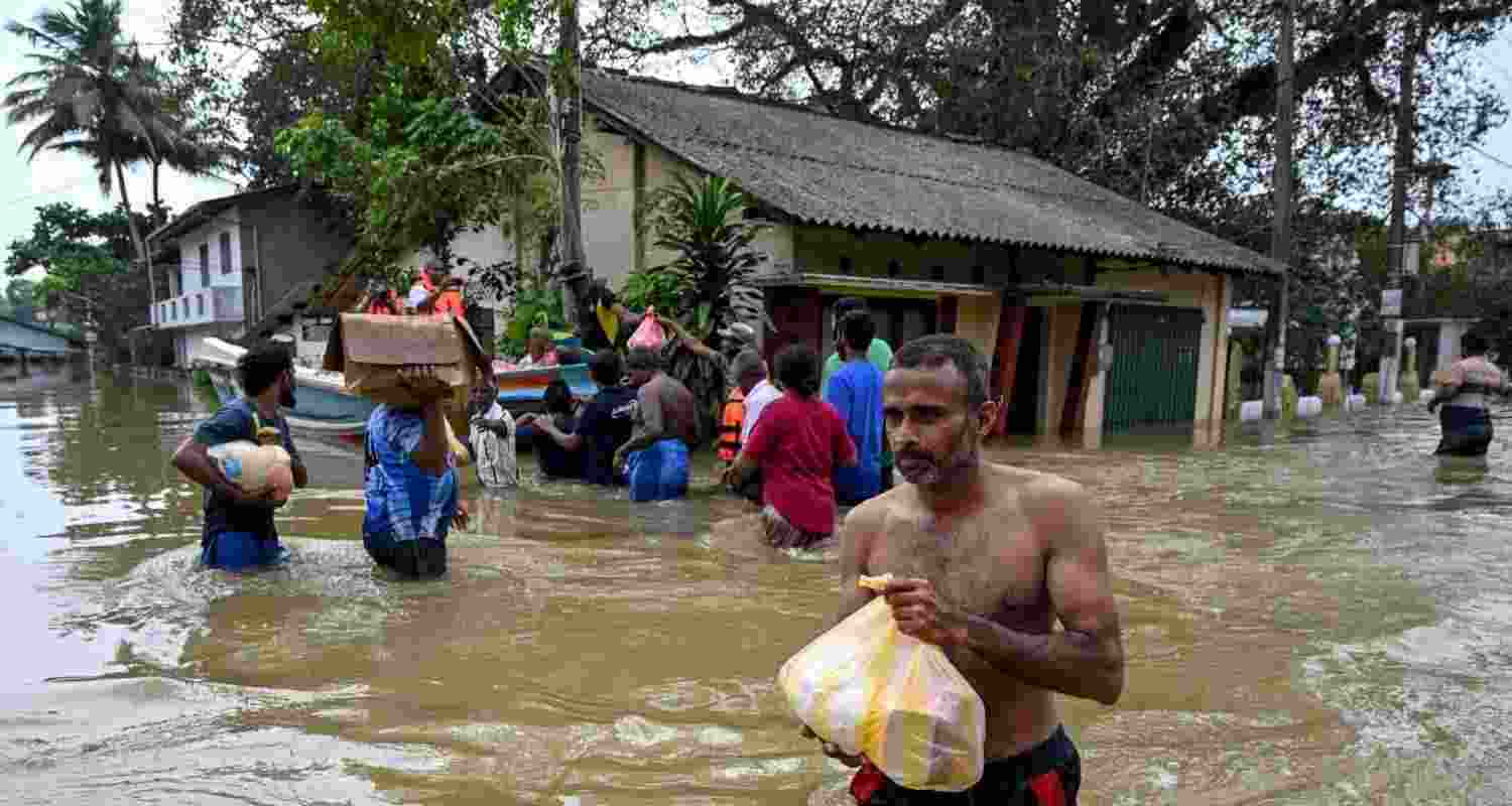 Residents wade through a flooded area in Wellampitiya on the outskirts of Colombo, Sri Lanka, on Monday. Residents wade through a flooded area in Wellampitiya on the outskirts of Colombo, Sri Lanka, on Monday.