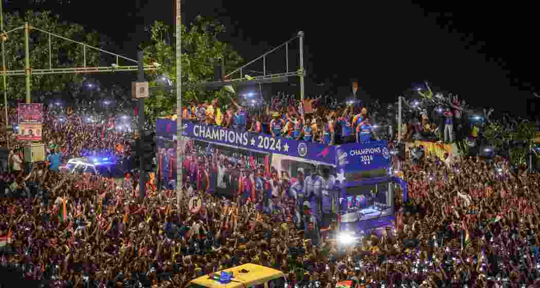Players of the T20 World Cup-winning Indian cricket team with the championship trophy acknowledge fans during their open bus victory parade, in Mumbai, Thursday, July 4, 2024. Players of the T20 World Cup-winning Indian cricket team with the championship trophy acknowledge fans during their open bus victory parade, in Mumbai, Thursday, July 4, 2024.