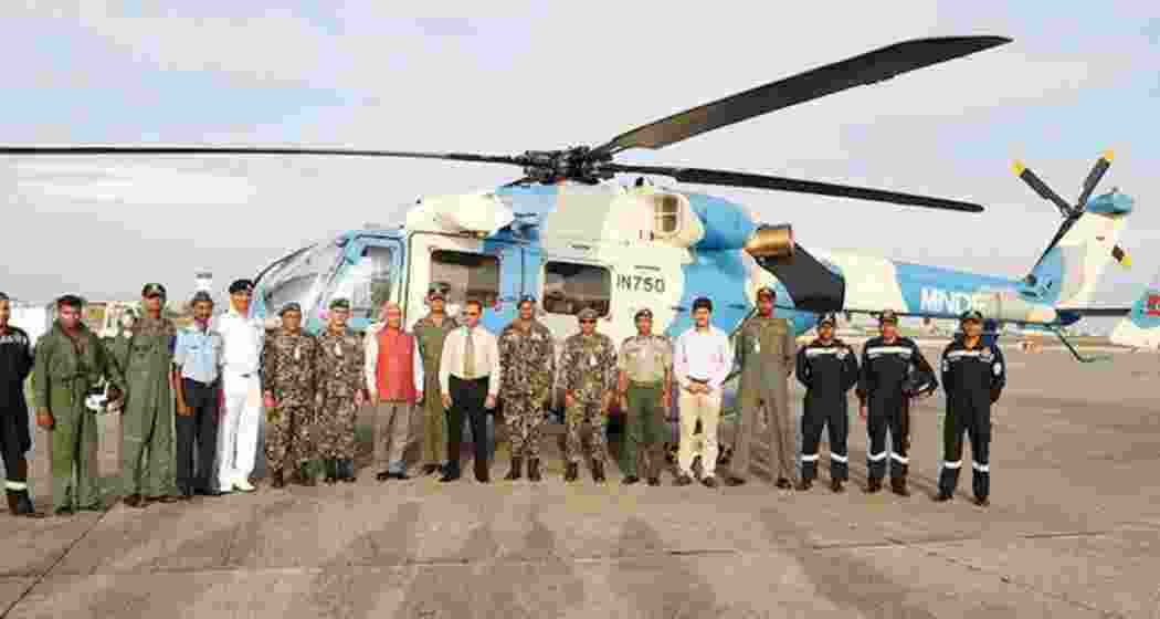 Indian military personnel pose with the helicopter gifted to the Maldives by India. Indian military personnel pose with the helicopter gifted to the Maldives by India.