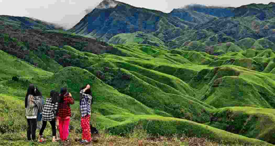 A group of tourists pause to photograph and admire the serene mountains of Manipur. A group of tourists pause to photograph and admire the serene mountains of Manipur.