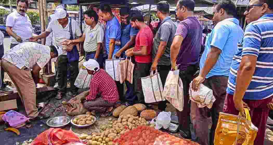 People queue up to purchase potatoes at subsidised rates from a West Bengal Government’s Food Department outlet, in Balurghat. People queue up to purchase potatoes at subsidised rates from a West Bengal Government’s Food Department outlet, in Balurghat.