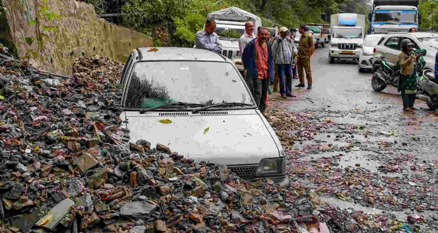 Workers clear a road that was blocked by an uprooted tree following heavy rainfall, in Shimla, Thursday.  Workers clear a road that was blocked by an uprooted tree following heavy rainfall, in Shimla, Thursday.