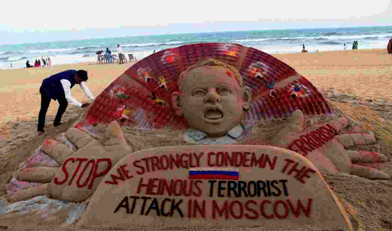 Artist Sudarsan Pattnaik at a beach in Odisha's Puri adding final touches to his sand sculpture condemning the Moscow concert hall attack. (PTI) Artist Sudarsan Pattnaik at a beach in Odisha's Puri adding final touches to his sand sculpture condemning the Moscow concert hall attack. (PTI)