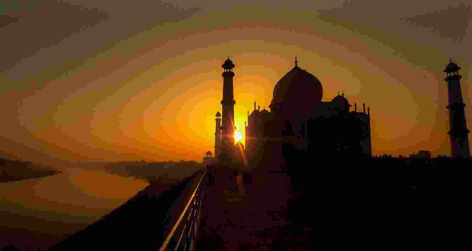 The silhouette of the Taj Mahal emerges against the vibrant hues of a sunrise, casting a mesmerising shadow that epitomizes the majestic beauty of India's architectural marvel. The silhouette of the Taj Mahal emerges against the vibrant hues of a sunrise, casting a mesmerising shadow that epitomizes the majestic beauty of India's architectural marvel.