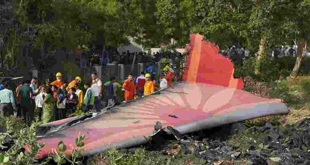Security personnel, disaster management teams and locals near a wing section at the Ahmedabad crash site. Security personnel, disaster management teams and locals near a wing section at the Ahmedabad crash site.