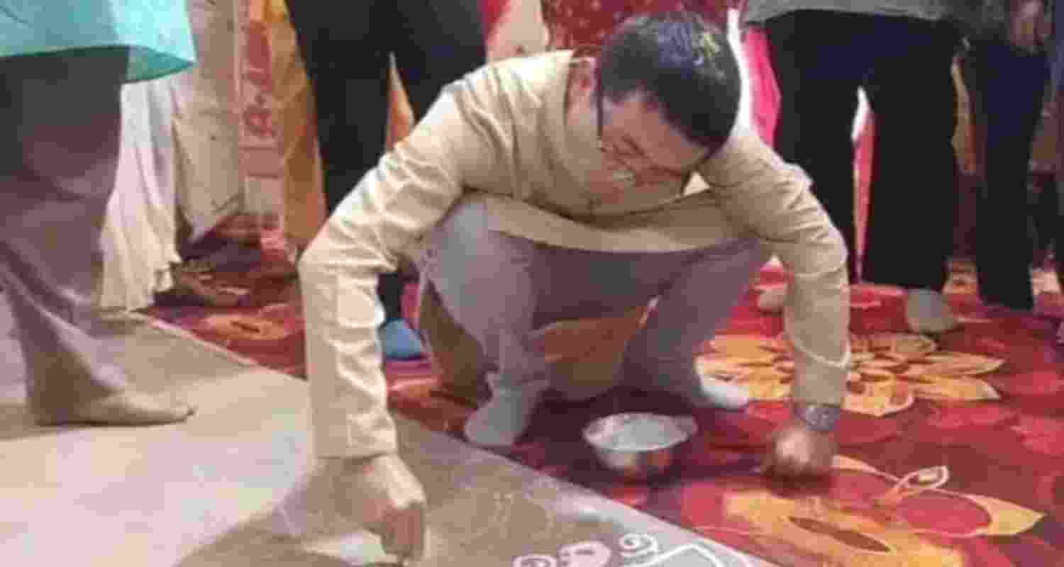 A Chinese guest offers alpana— handiwork on the floor where the Durga Puja is taking place. A Chinese guest offers alpana— handiwork on the floor where the Durga Puja is taking place.