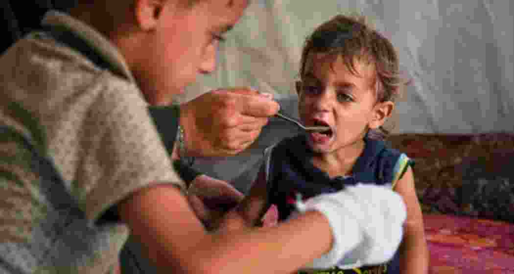 A Palestinian boy receives a meal from a community kitchen at the Muwasi displacement camp in Khan Younis, Gaza, on May 18. A Palestinian boy receives a meal from a community kitchen at the Muwasi displacement camp in Khan Younis, Gaza, on May 18.