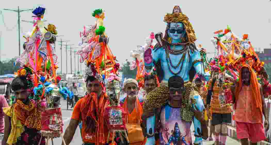 Kanwariyas, devotees of Lord Shiva, walk along a road during the annual Kanwar Yatra in the holy month of Shravan, in New Delhi, Tuesday. Kanwariyas, devotees of Lord Shiva, walk along a road during the annual Kanwar Yatra in the holy month of Shravan, in New Delhi, Tuesday.