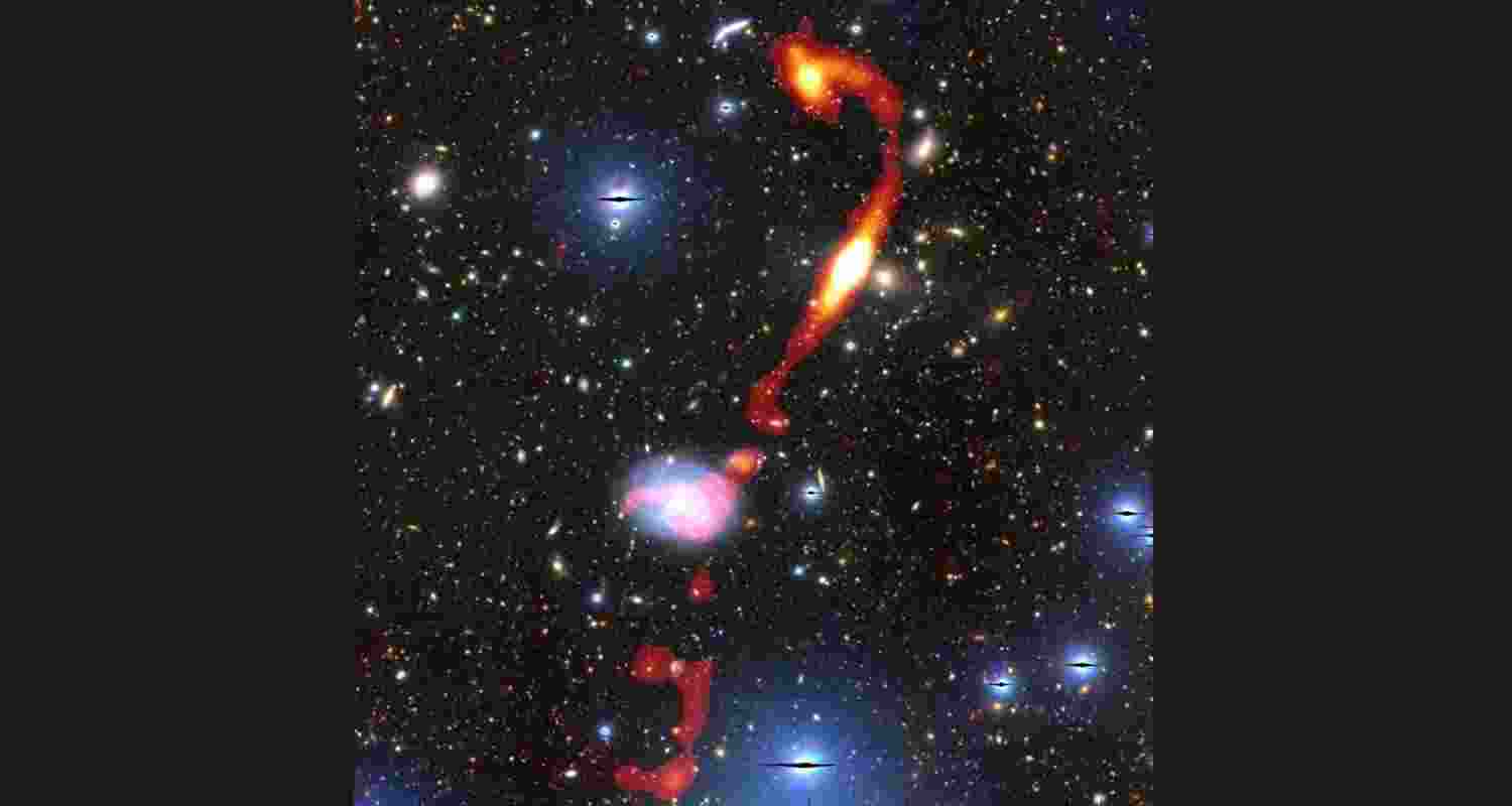 Inkathazo’s glowing plasma jets are shown in red and yellow. The starlight from other surrounding galaxies can be seen in the background. Inkathazo’s glowing plasma jets are shown in red and yellow. The starlight from other surrounding galaxies can be seen in the background.