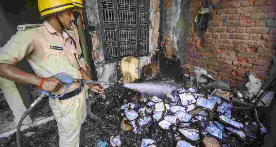 Police personnel douse a fire at a school that was torched after a four-year-old child was allegedly found dead near the school premises Police personnel douse a fire at a school that was torched after a four-year-old child was allegedly found dead near the school premises