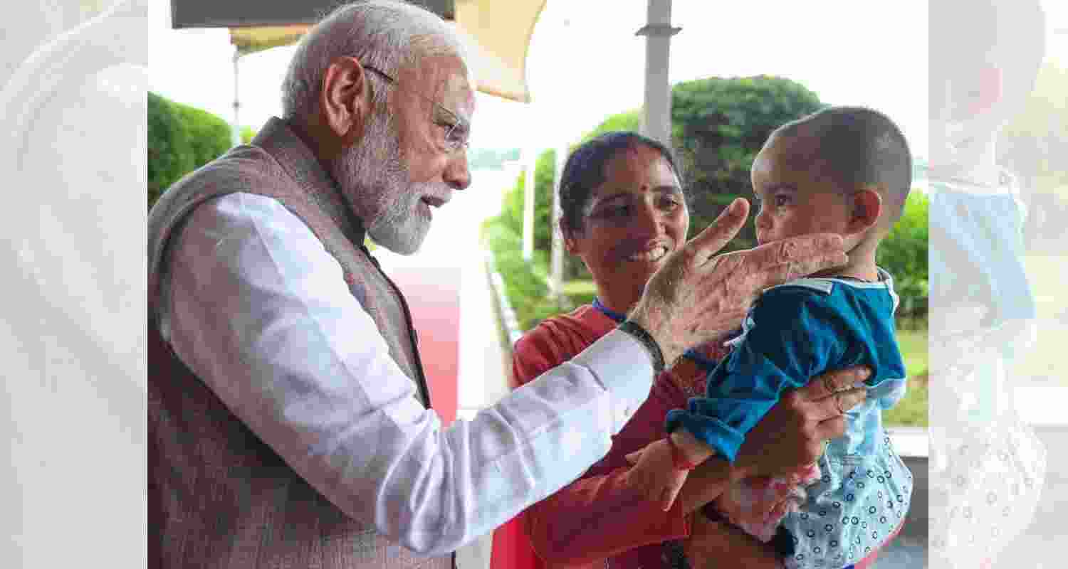 Prime Minister Narendra Modi with one year old Nitika who lost her parents in a cloudburst in Mandi on the night of June 30. Prime Minister Narendra Modi with one year old Nitika who lost her parents in a cloudburst in Mandi on the night of June 30.