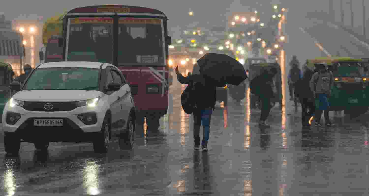 Vehicles move on a road amid rain, in Noida, Friday. Vehicles move on a road amid rain, in Noida, Friday.