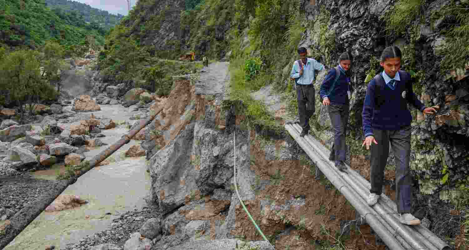 School students use a makeshift bridge to cross the damaged portion of Gumma-Basantpur road following heavy rainfall, at Sunni in Shimla on Monday. School students use a makeshift bridge to cross the damaged portion of Gumma-Basantpur road following heavy rainfall, at Sunni in Shimla on Monday.