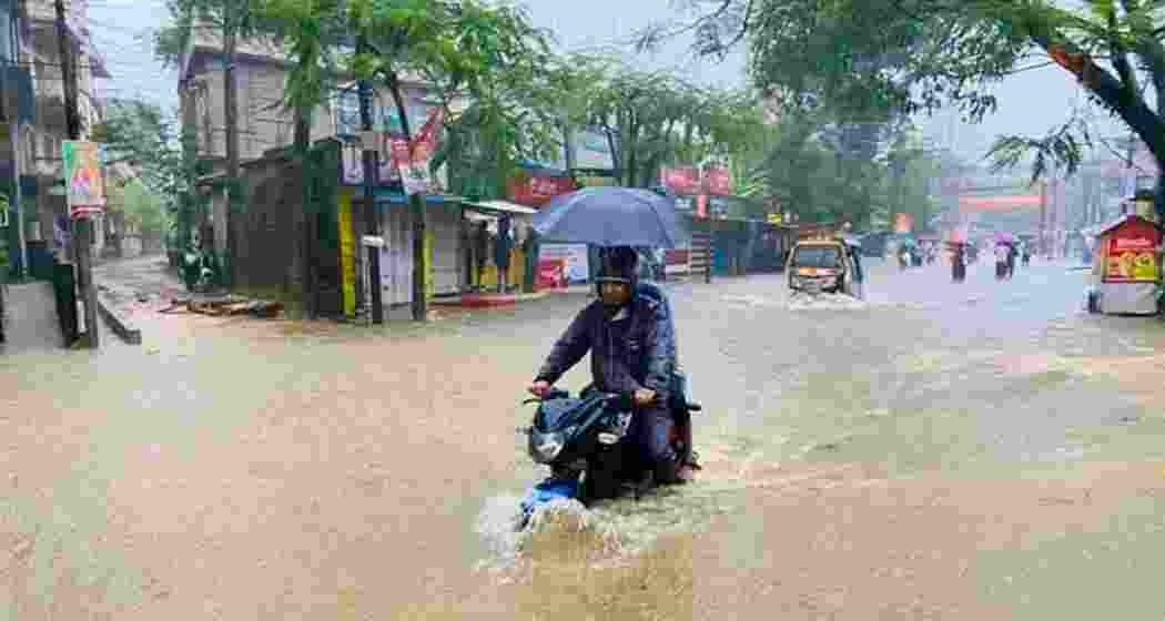 People ride a motorbike through an inundated road in Silchar on Sunday, after the city recorded its highest single-day rainfall in 132 years. People ride a motorbike through an inundated road in Silchar on Sunday, after the city recorded its highest single-day rainfall in 132 years.