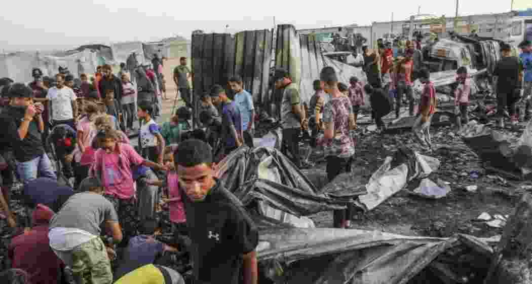 Children wait for food distribution outside the UNRWA shelter in al-Mawasi. Children wait for food distribution outside the UNRWA shelter in al-Mawasi.